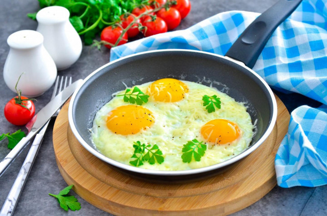 Fried eggs with cheese in a frying pan