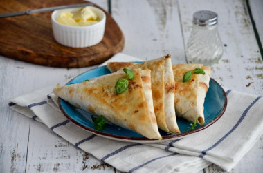 Lavash envelopes with different fillings on frying pan