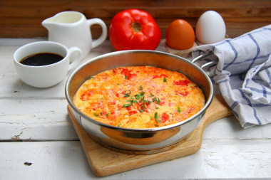 Omelet with tomatoes in a frying pan