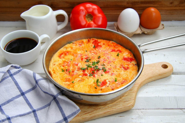 Omelet with tomatoes in a frying pan