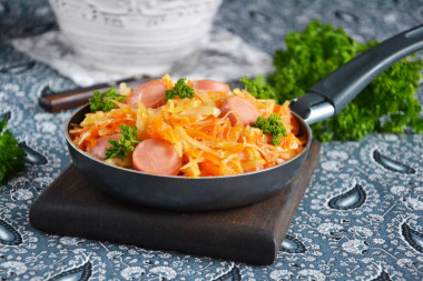 Stewed cabbage with sausages in a frying pan