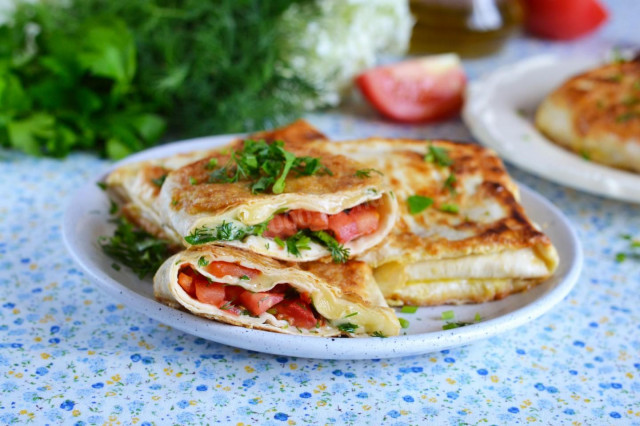 Pita bread with cheese and tomatoes in a frying pan