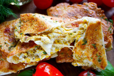 Lavash with egg and cheese in a frying pan