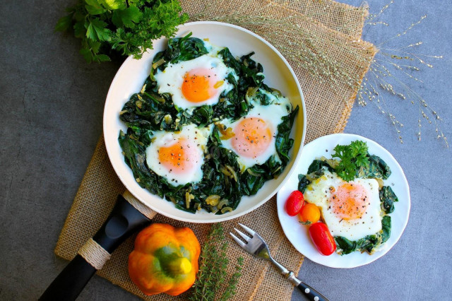 Spinach with egg in a frying pan
