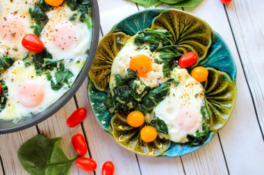 Spinach with egg in a frying pan