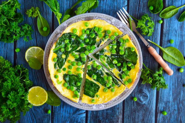 Omelet with spinach in a frying pan