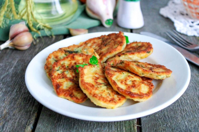 Squash fritters with cheese in a frying pan
