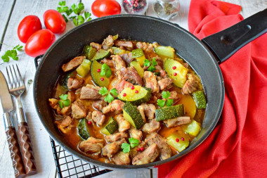 Pork with zucchini stewed in a frying pan