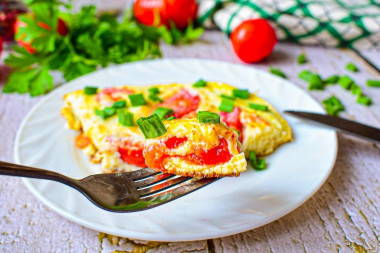 Omelet with tomatoes and cheese in a frying pan