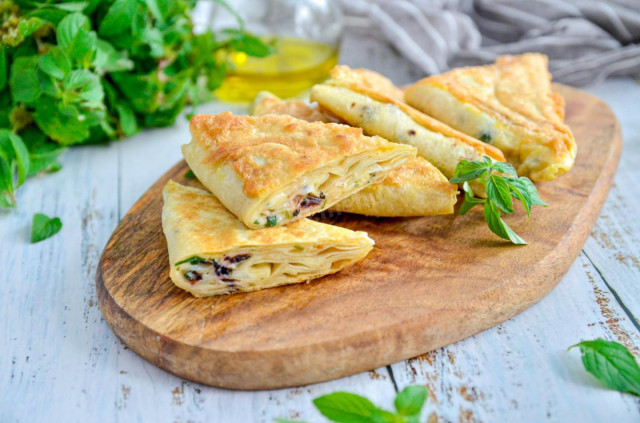 Pita bread pies with cheese in a frying pan