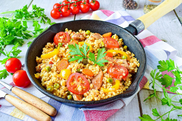Bulgur with pork meat and vegetables in a frying pan