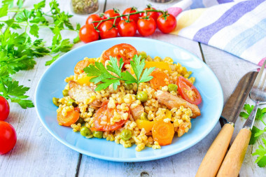 Bulgur with pork meat and vegetables in a frying pan