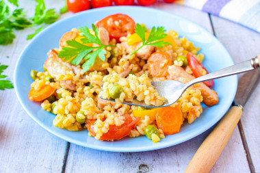 Bulgur with pork meat and vegetables in a frying pan