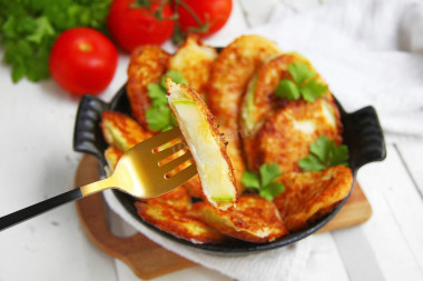 Zucchini in batter with cheese in a frying pan