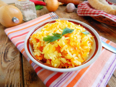 Rice in a frying pan with onions and carrots