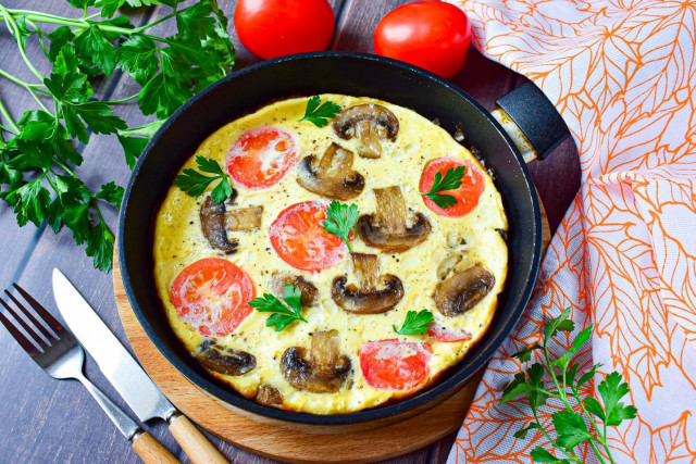 Omelet with mushrooms and cheese in a frying pan for breakfast