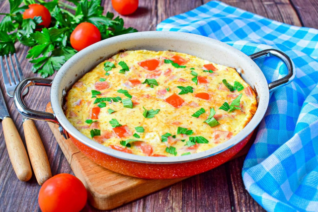 Omelet with ham and cheese in a frying pan