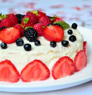 Pancake cake with cottage cheese and berries in a frying pan