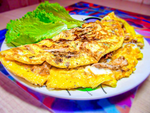 Omelet with chicken and cheese in a frying pan