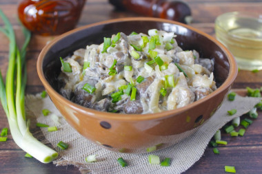 Oyster mushrooms in sour cream in a frying pan