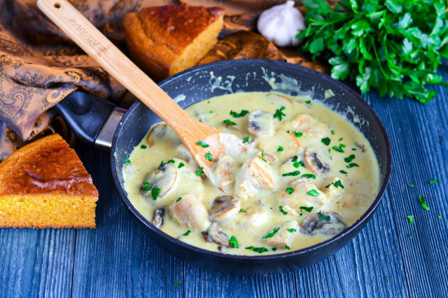 Chicken breast with mushrooms and cheese in a frying pan