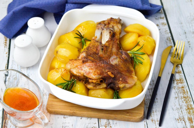 Pork knuckle baked with potatoes in the oven