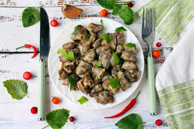 Stewed chicken hearts in sour cream in a slow cooker