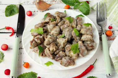 Stewed chicken hearts in sour cream in a slow cooker