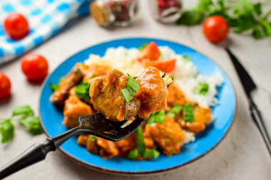 Pork with mushrooms in a frying pan in sauce with onions