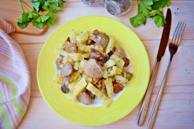 Potatoes with mushrooms in a frying pan with sour cream