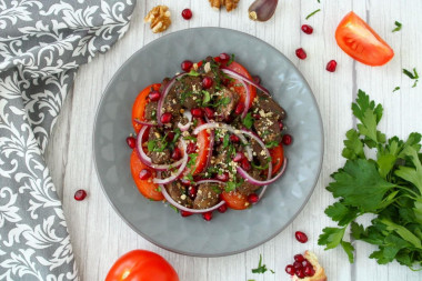 Salad with chicken liver and tomatoes, nuts and pomegranate