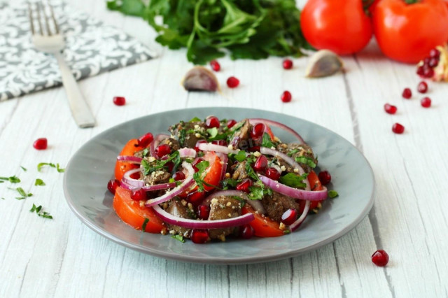 Salad with chicken liver and tomatoes, nuts and pomegranate