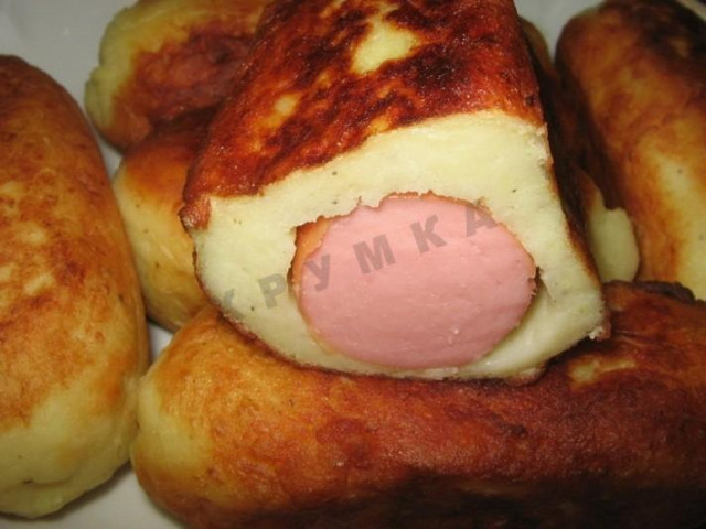 Sausages in potato dough in a frying pan