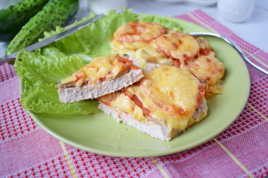 Pork with mayonnaise, tomatoes, champignons and cheese