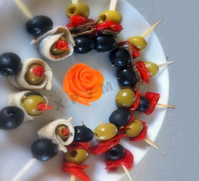 Canapes with olives, anchovies, bell peppers on skewers