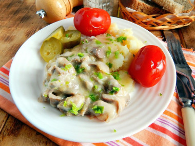 Chicken fillet with mushrooms in a frying pan in cream