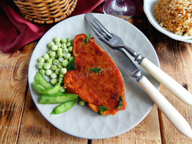 Pork steak in a frying pan with black pepper