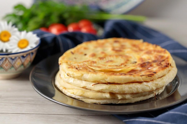 Uzbek flatbreads with onions in a frying pan