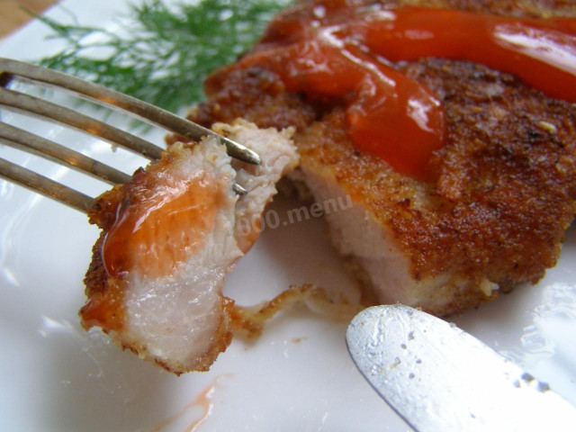 Pork chops in potato batter in a frying pan