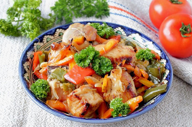 Chicken fillet with onions and carrots in a frying pan