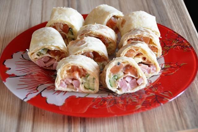 Lavash roll with salmon, melted cheese, cucumber and herbs