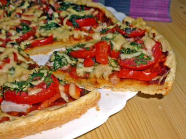 Pizza on liquid dough with pork, tomatoes and peppers