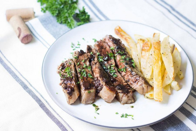 Entrecote with onions in a frying pan