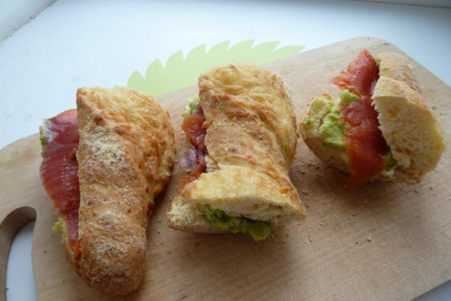 Festive sandwich on a baguette with avocado and red fish
