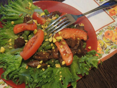 The salad is warm with beef, nuts and vegetables