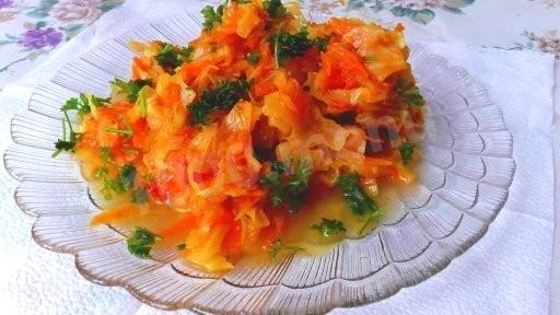 Cabbage pumpkin carrot onion stewed with tomatoes in a frying pan