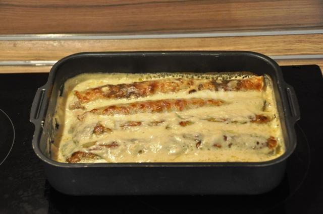 Pancakes stuffed with mushrooms in cheese sauce