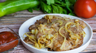 Pork chops with onions in a frying pan