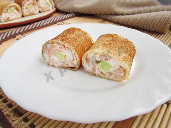 Rolls of ready-made pancakes with avocado and salmon