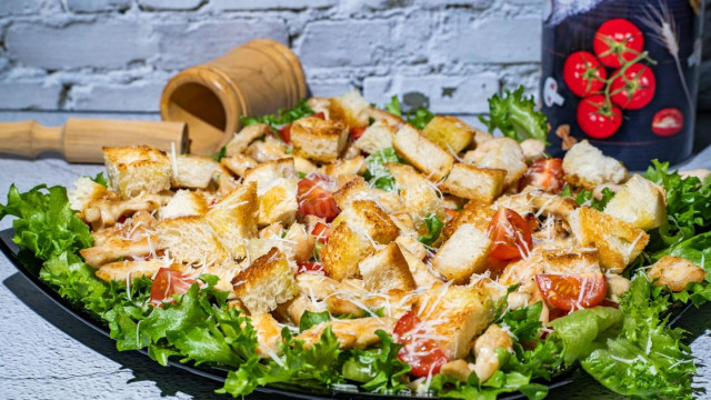 Caesar salad with chicken and crackers with sauce